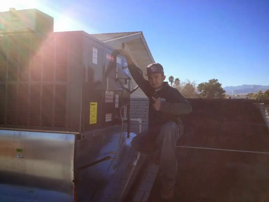 HVAC technician performing HVAC Inspection on a rooftop unit in Barstow